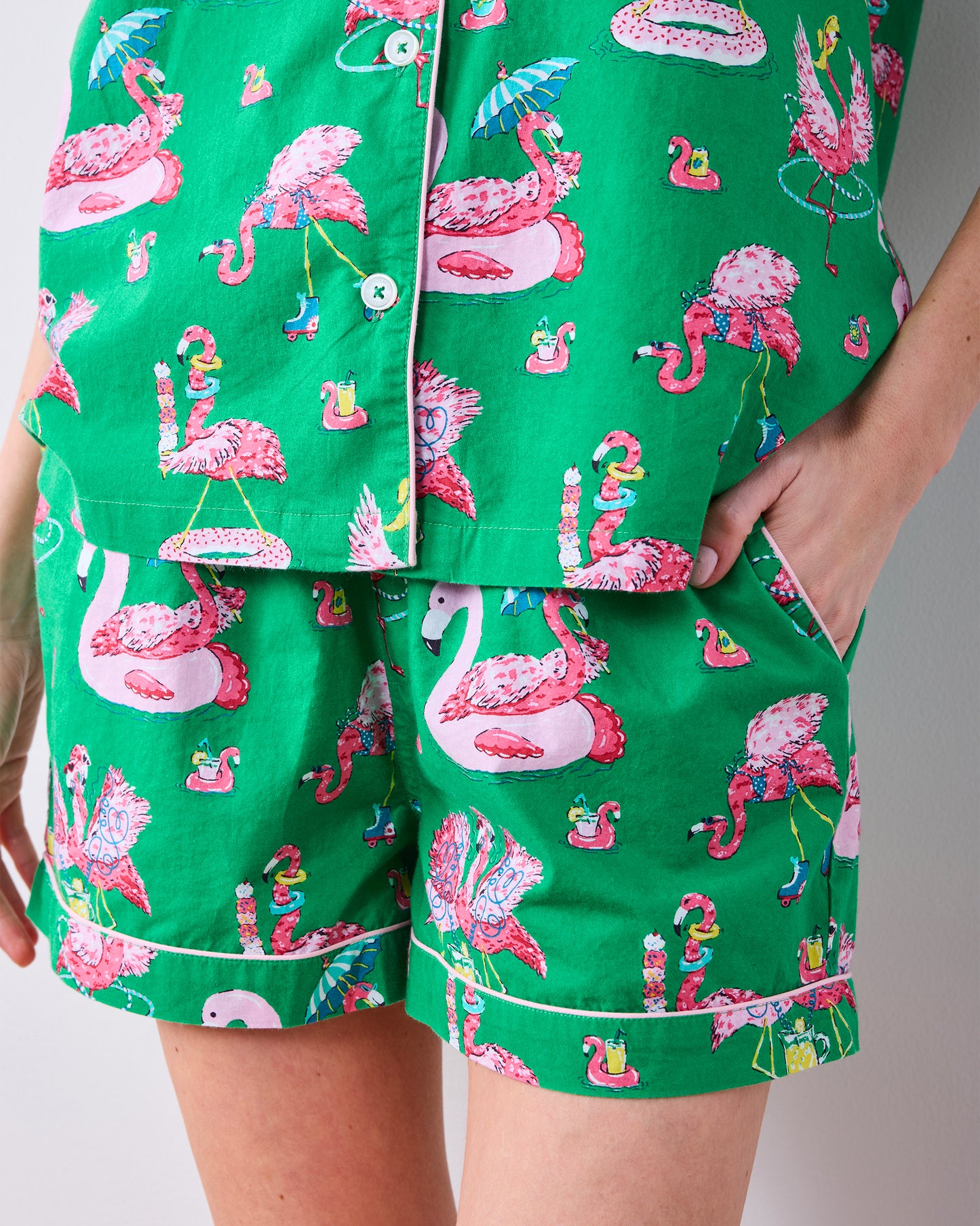 Close-up of the Palm Frond pajama top, flamingo-print shorts, contrast piping, and side pocket