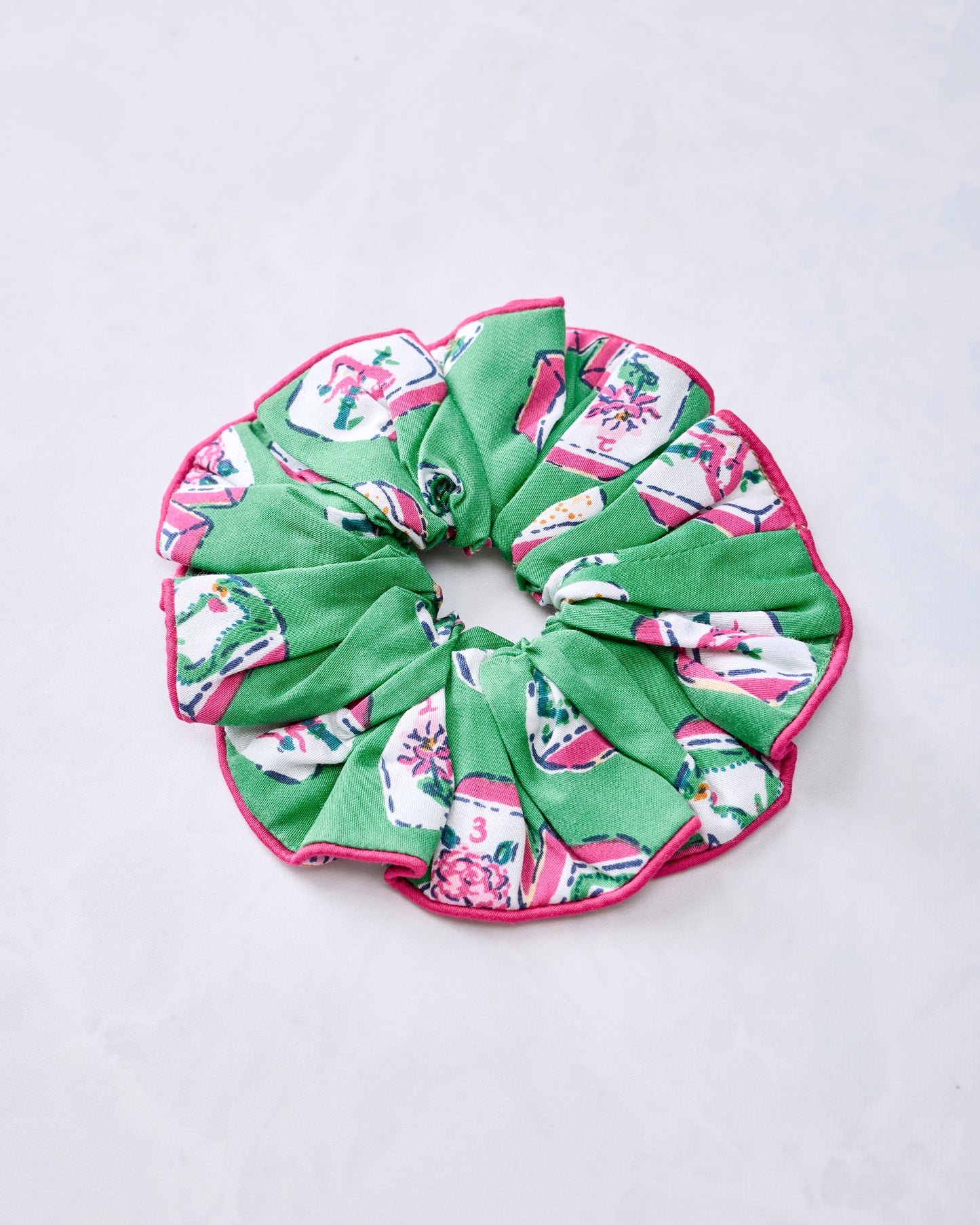 Green scrunchie with multicolored Mah Jongg tile print and pink edging