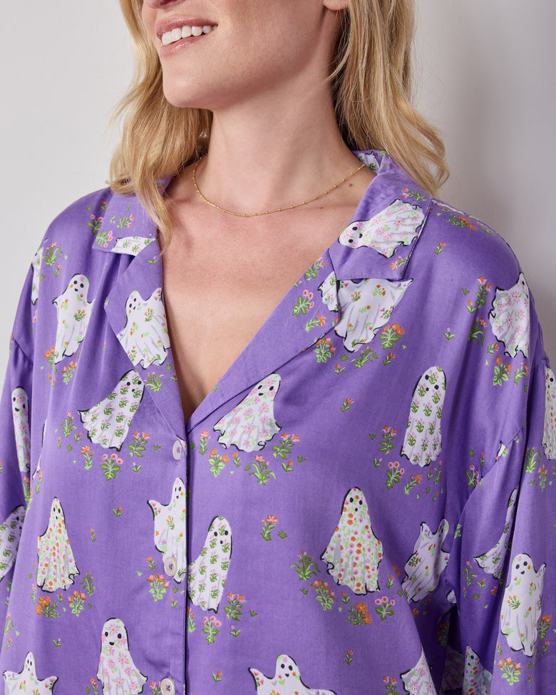 Close-up of the purple Gardening Ghosts pajama top with a notched collar, buttons, and white ghost-and-floral print.