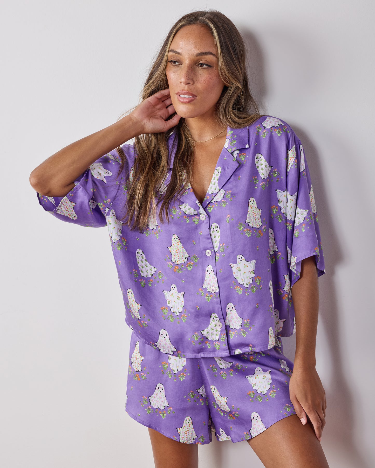 Front view of the Eerie Amethyst Gardening Ghosts short pajama set, showing the relaxed collared top, matching shorts, and ghost-and-flower print.