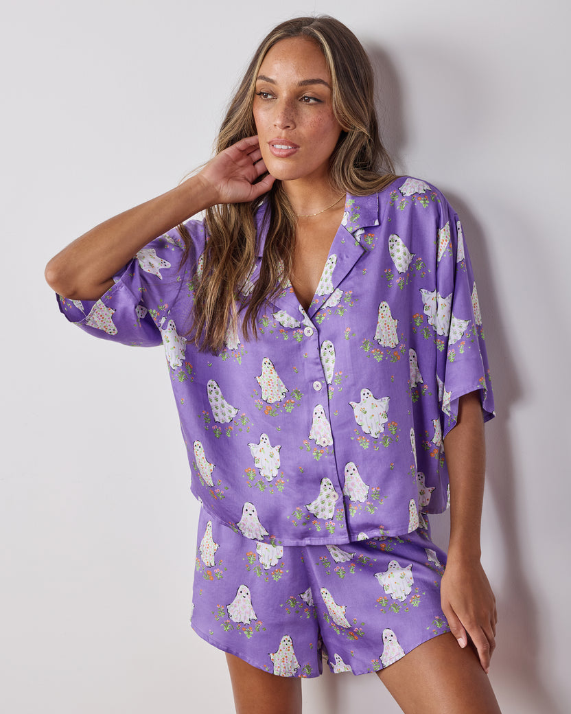 Front view of the Eerie Amethyst Gardening Ghosts short pajama set, showing the relaxed collared top, matching shorts, and ghost-and-flower print.