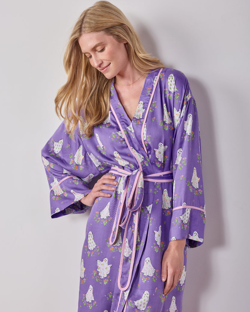 Angled front view of the purple ghost-and-floral print robe showing the wrap front, matching belt, and wide sleeves.