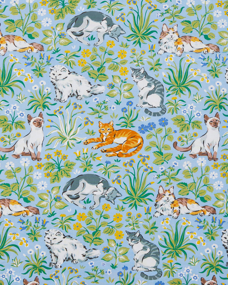 Cornflower-blue print with lounging cats among green leaves and blue, yellow, and white flowers