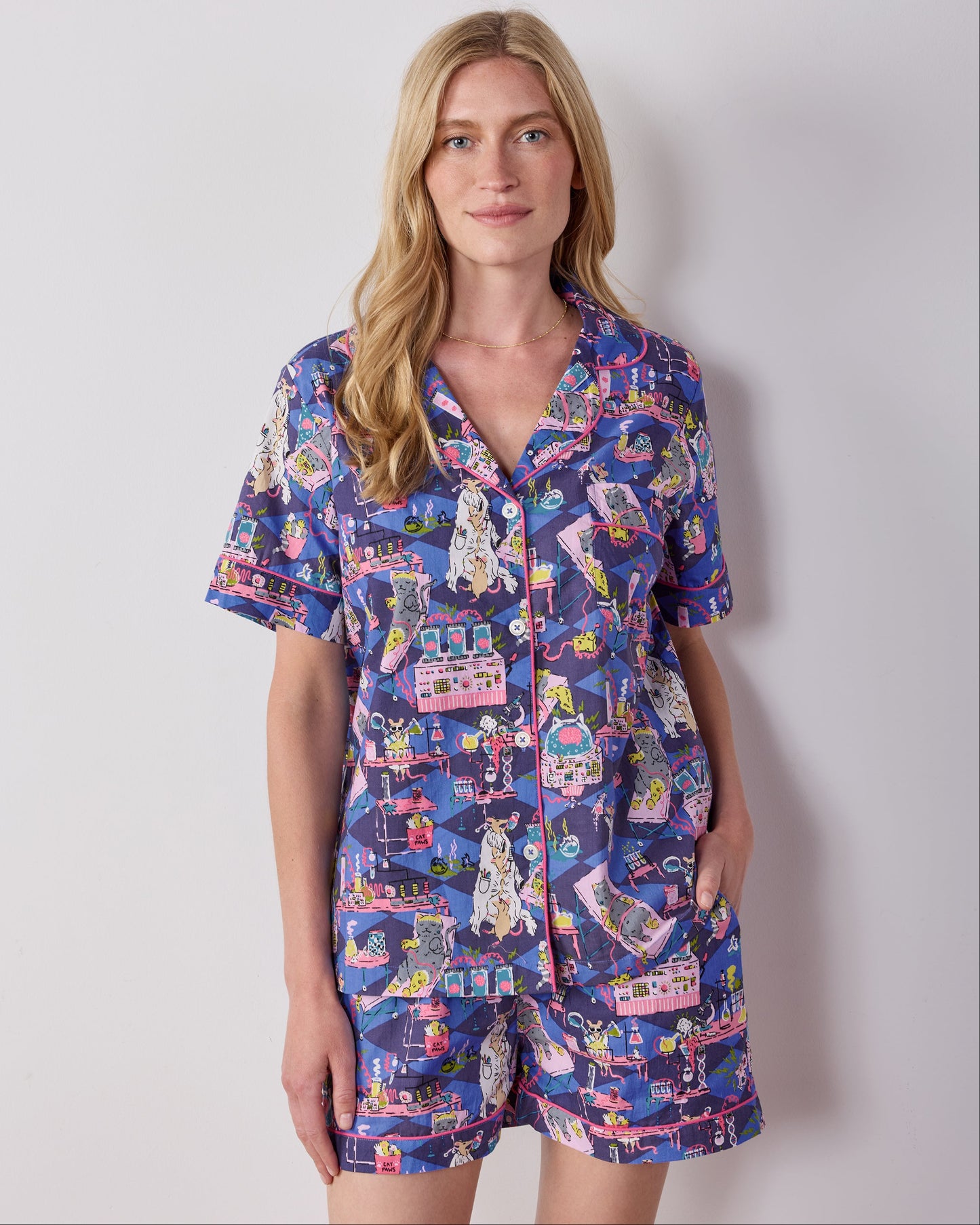 Front view of the blue It's Alive short pajama set with a button-front collared top and matching shorts covered in a colorful laboratory cat-and-mouse print.