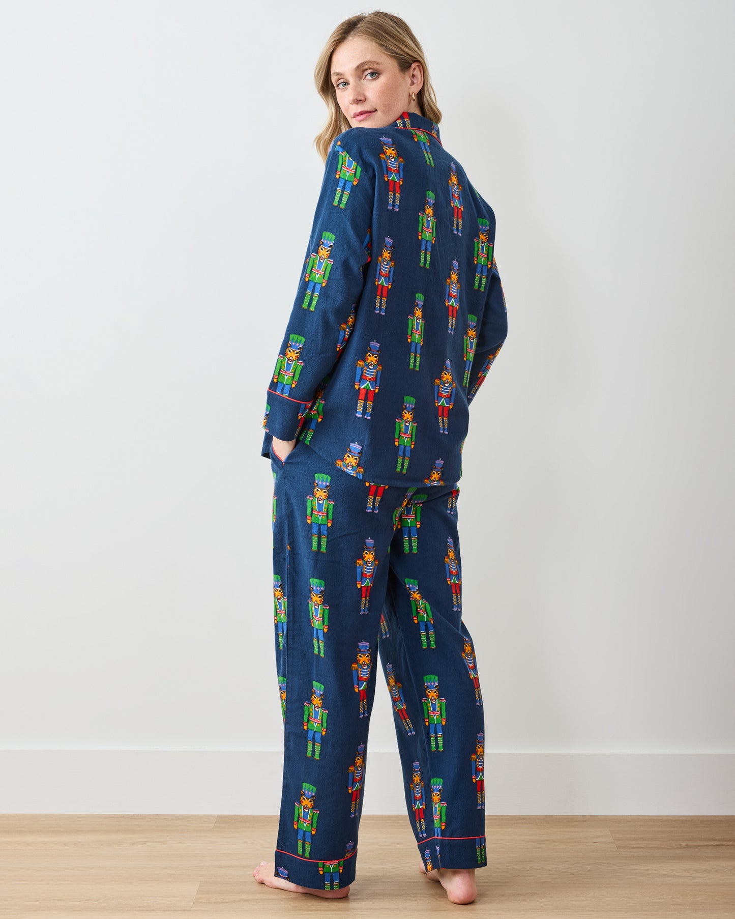 Back view of navy long pajama set with colorful leopard nutcracker print and red piping