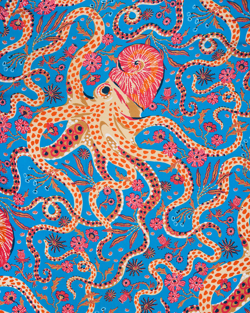 Octopus Isle print detail with cream octopuses, red shells, and flowers on a blue background