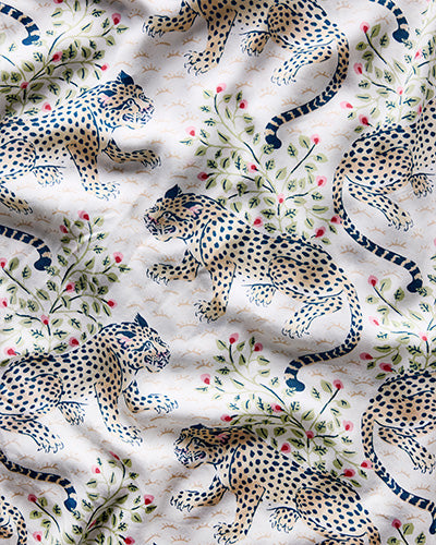 Close-up of the Bagheera print with spotted big cats among flowering vines on a pale background