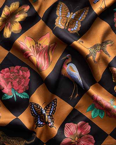 Caramel-and-black checkerboard print with flowers, butterflies, birds, and leopards
