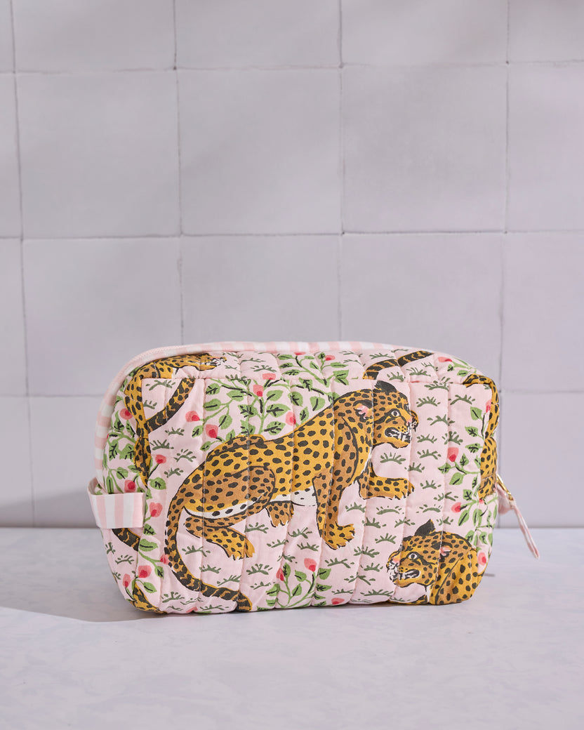 Front view of a pale pink quilted Bagheera pouch with leopard and leafy motifs.