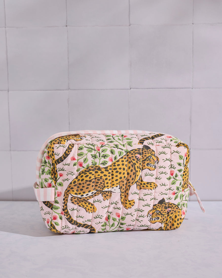 Front view of a pale pink quilted Bagheera pouch with leopard and leafy motifs.