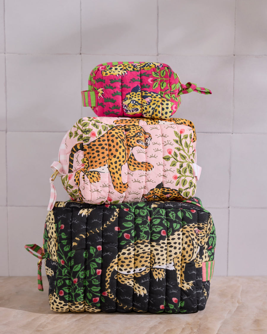Three stacked quilted Bagheera pouches in pink, black, green, and leopard prints.