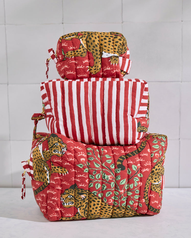 Three stacked quilted Bagheera pouches in red, leopard, green, and red-and-white striped prints.