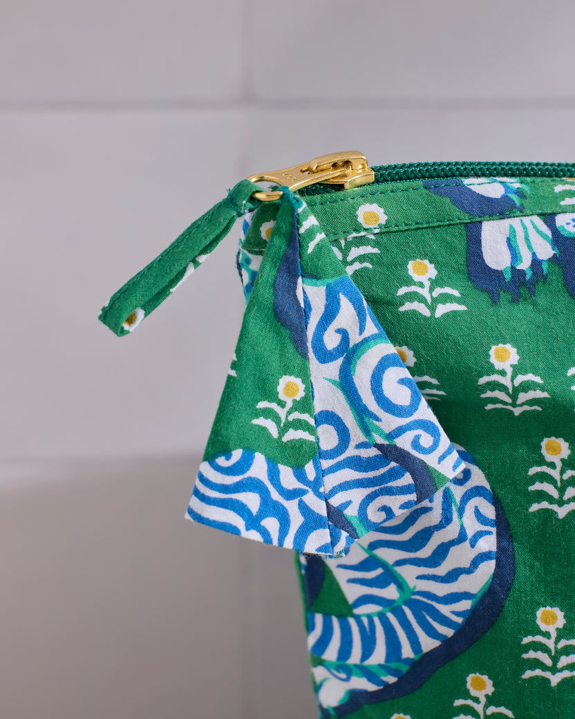 Close-up of the Tiger Queen essentials pouch showing the fabric zipper pull, gold-tone zipper, and side gusset.