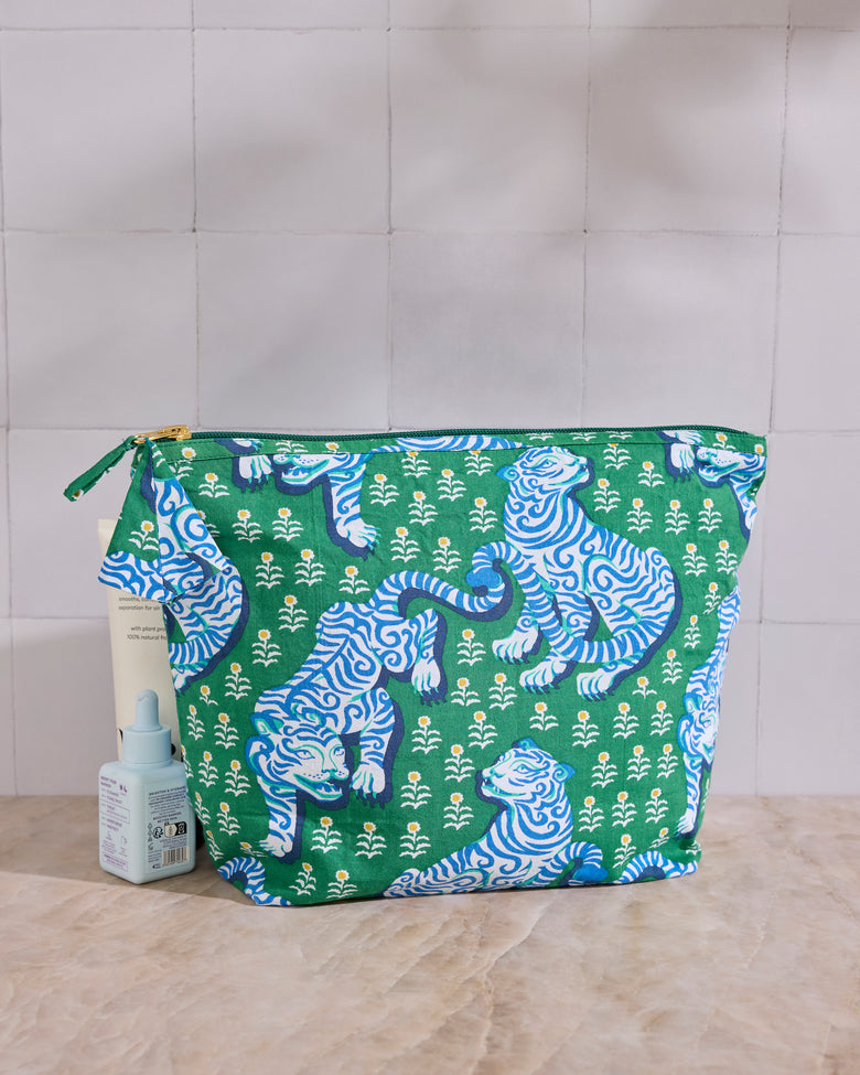 Tiger Queen essentials pouch in jade shown beside a small bottle and tube for scale.