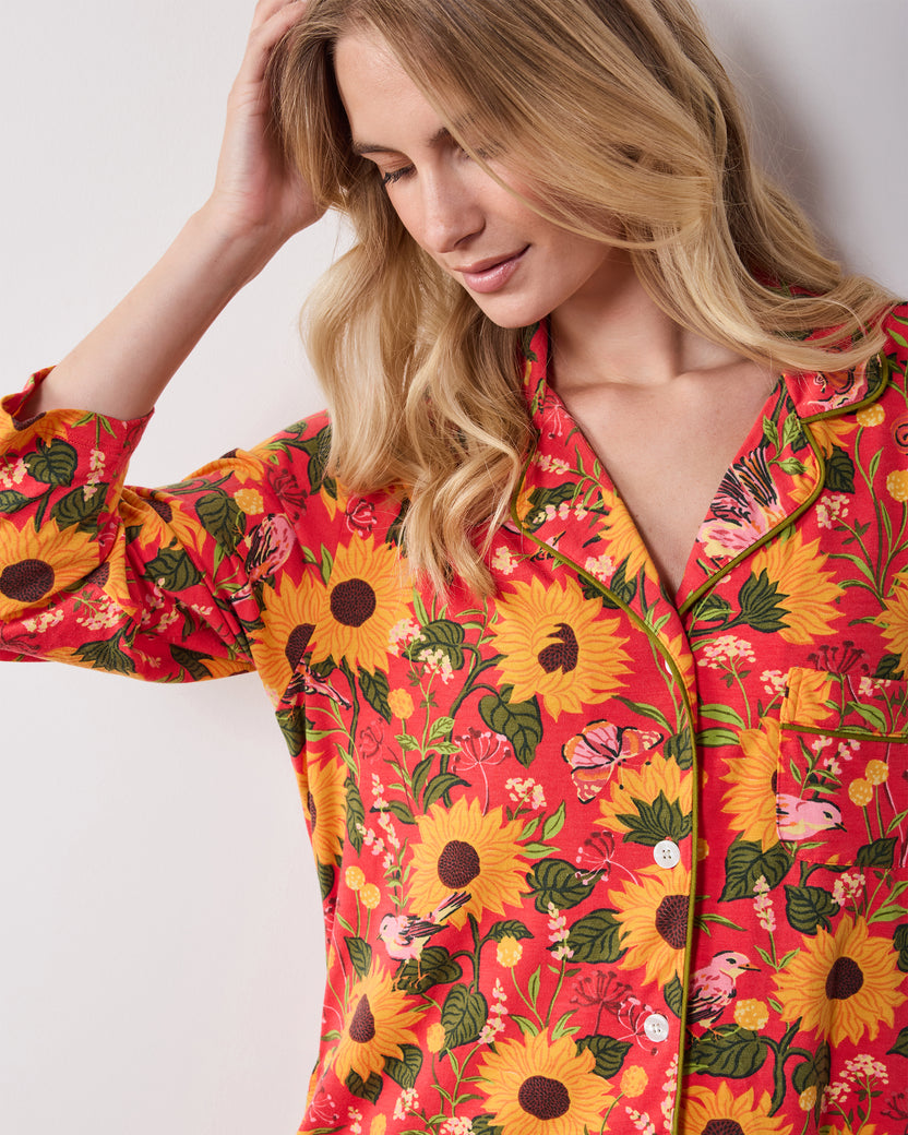 Close-up of the orange Autumn Sunflowers sleep shirt showing its collar, buttons, chest pocket, and print.