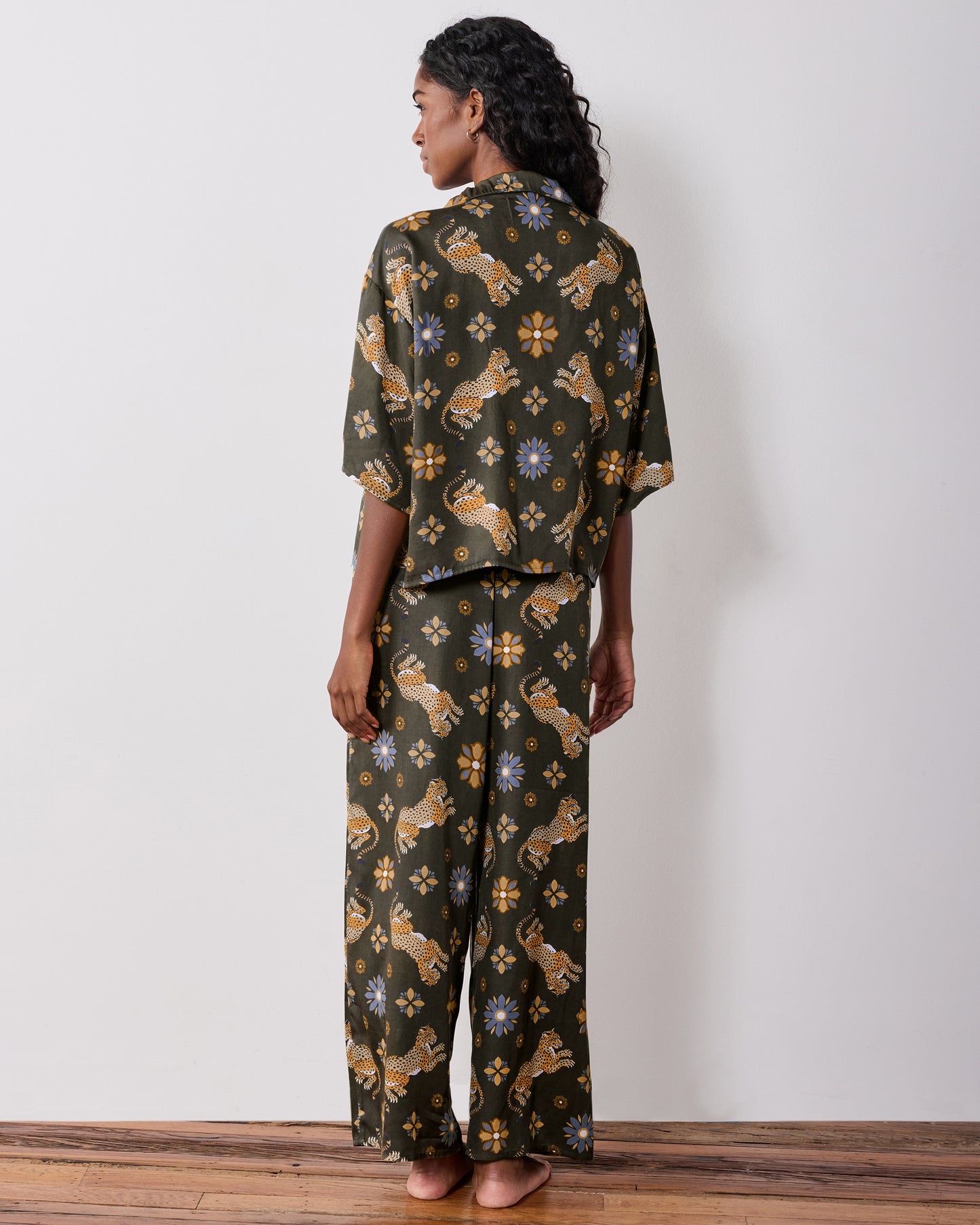 Back view of the olive Wildest Dreams pajama set, showing the short-sleeve shirt and wide-leg pants with leopard and flower prints.