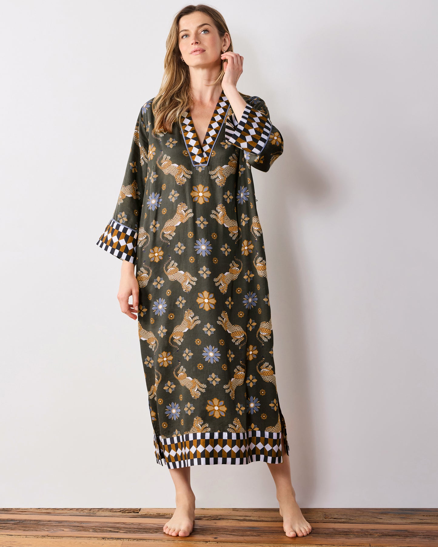 Full-length front view of the olive Bagheera Kaleidoscope Kennedy caftan, showing the geometric-trimmed V-neck, wide cuffs, and hem border.