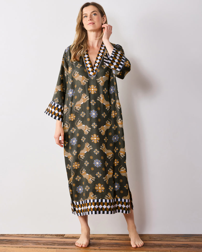 Full-length front view of the olive Bagheera Kaleidoscope Kennedy caftan, showing the geometric-trimmed V-neck, wide cuffs, and hem border.