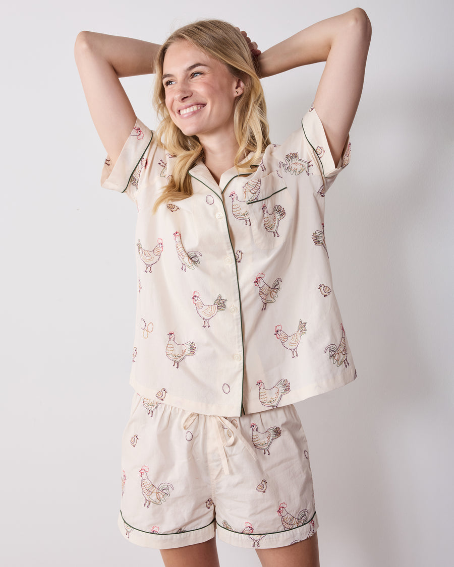 Front view of the short pajama set with a short-sleeve button-front top and matching shorts featuring embroidered hens.