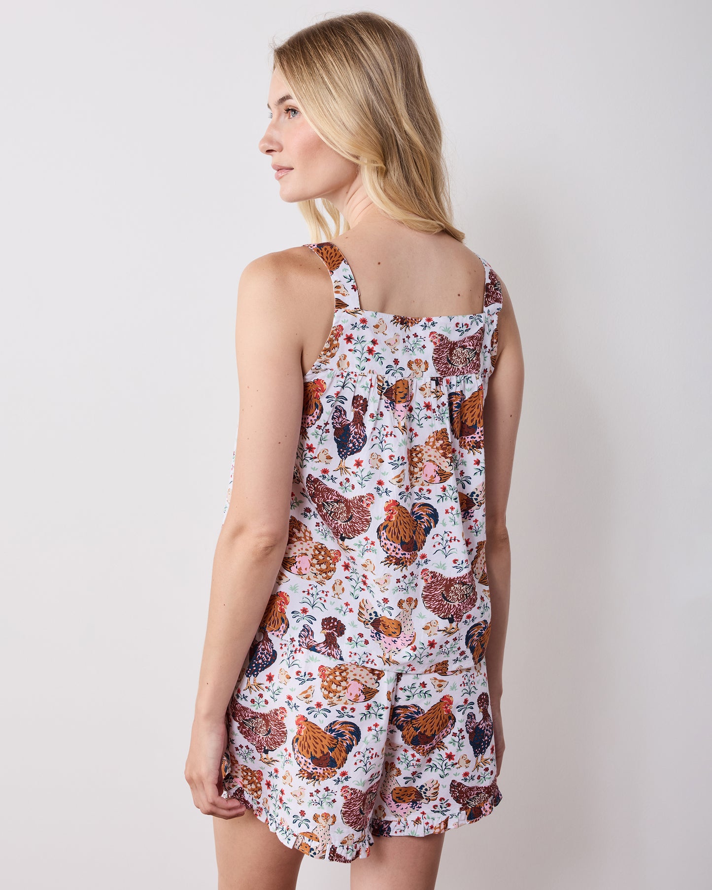 Back view of a printed short pajama set showing the camisole straps, gathered back, and matching ruffled shorts.