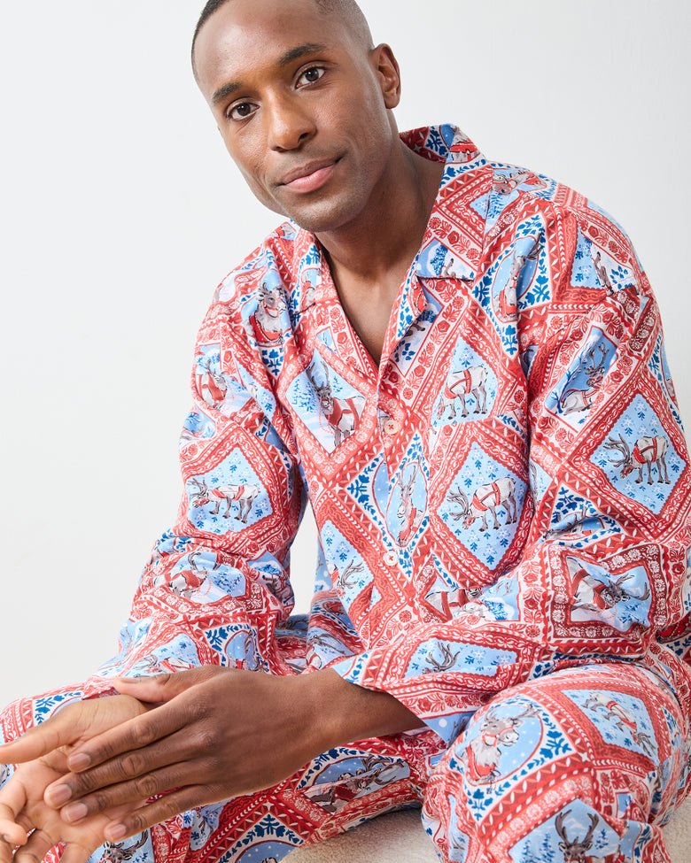 Seated close view of Reindeer Games pajama set with red framed reindeer print, button-front top, and patch pocket
