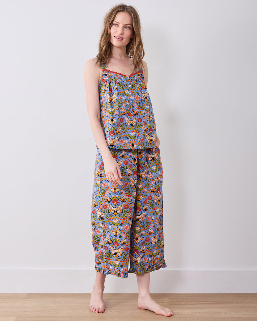 Full-length front view of a sleeveless top and wide-leg cropped pajama pants with a blue bee-and-floral print.