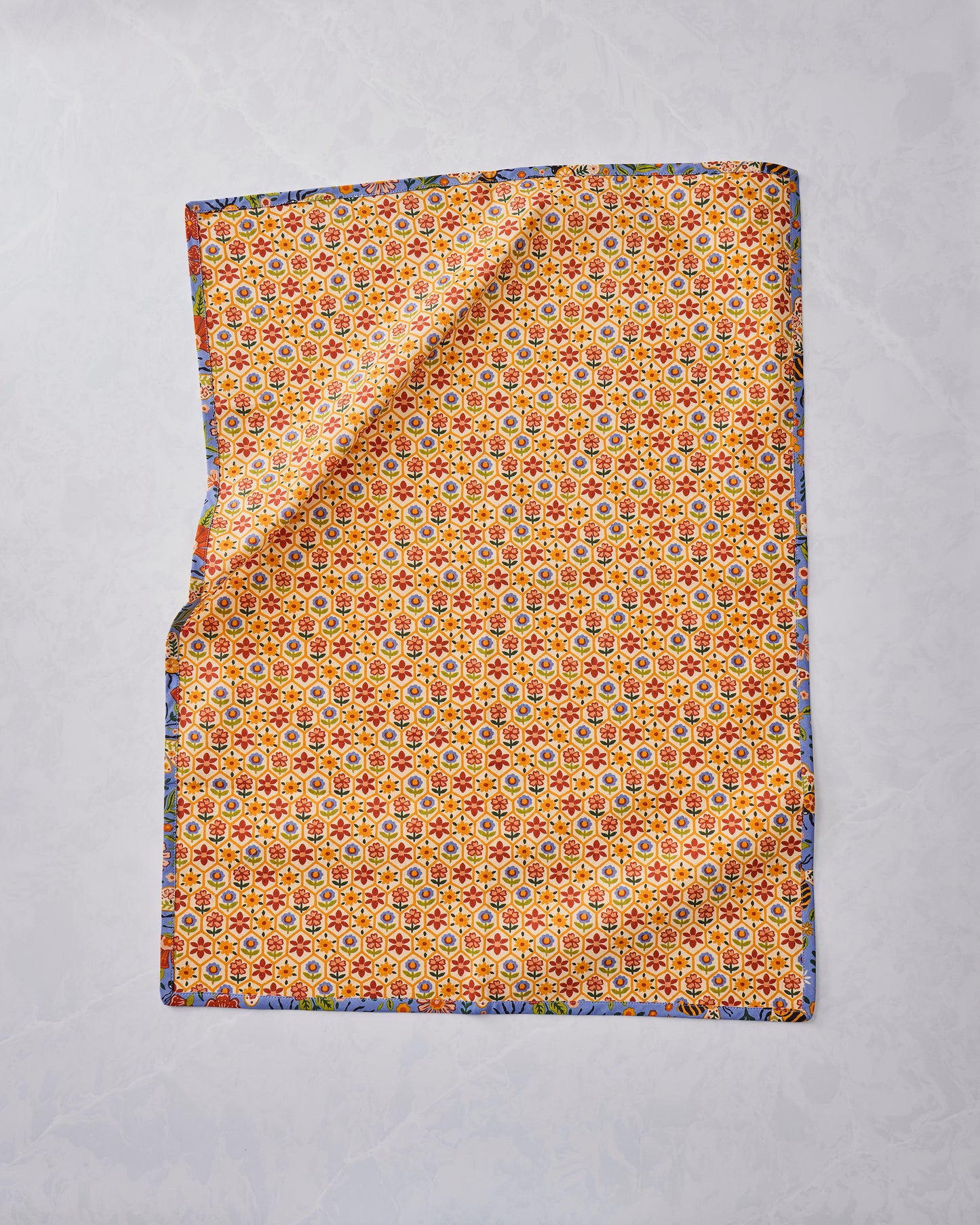 Bee Tapestry tea towel laid flat, showing a dense floral pattern with a blue printed border.