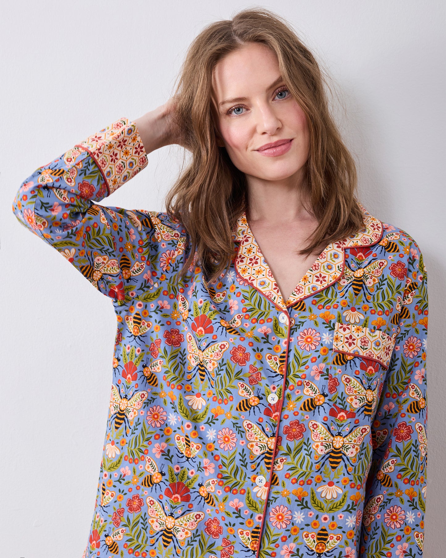 Close-up front view of the Bee Tapestry Delphinium Blue petite pajama top, showing its floral and bee print, contrasting collar and cuffs, buttons, and chest pocket.