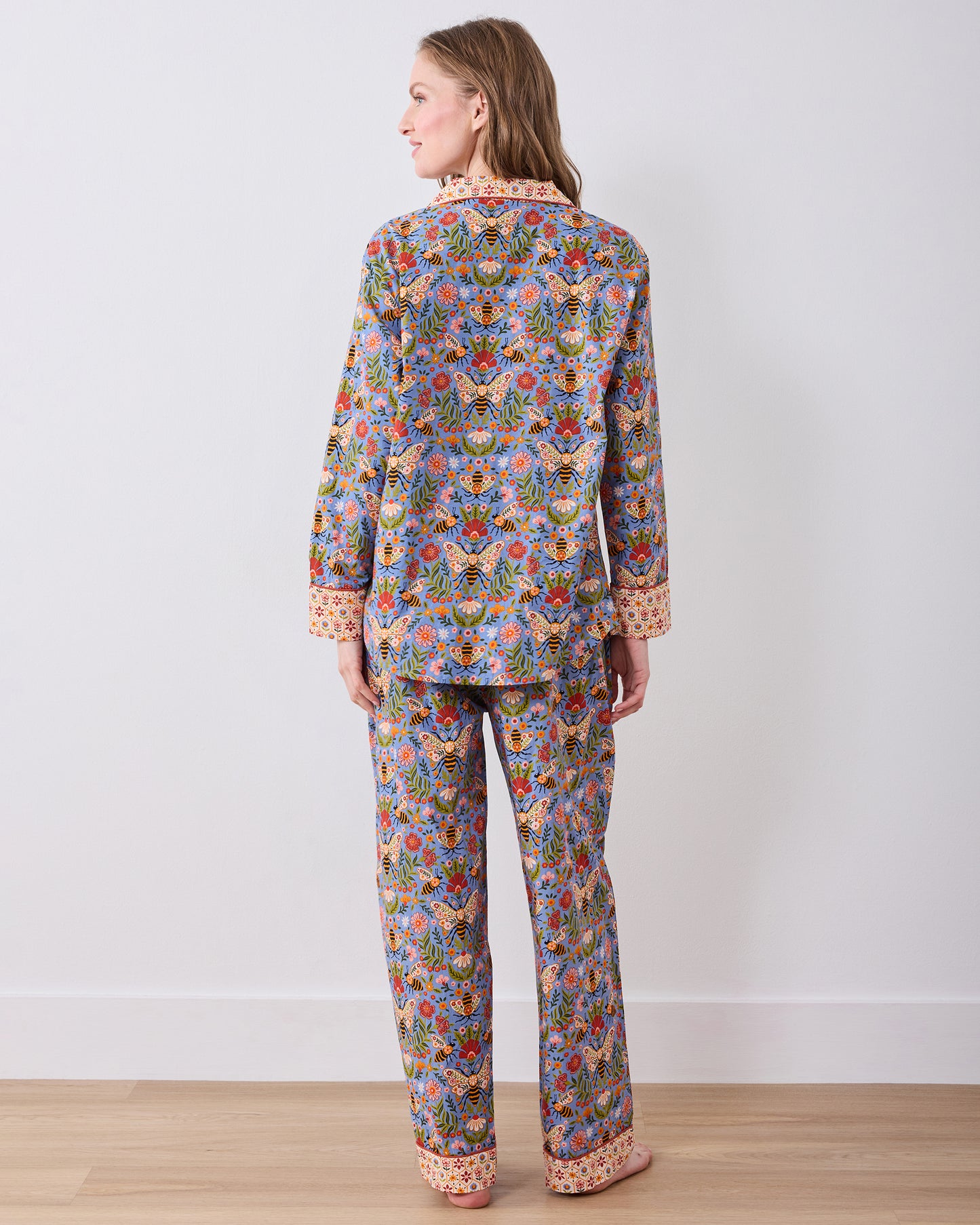 Back view of the Bee Tapestry Delphinium Blue long pajama set, showing the full-length button-down top and matching pants with contrasting cuffs and hem.