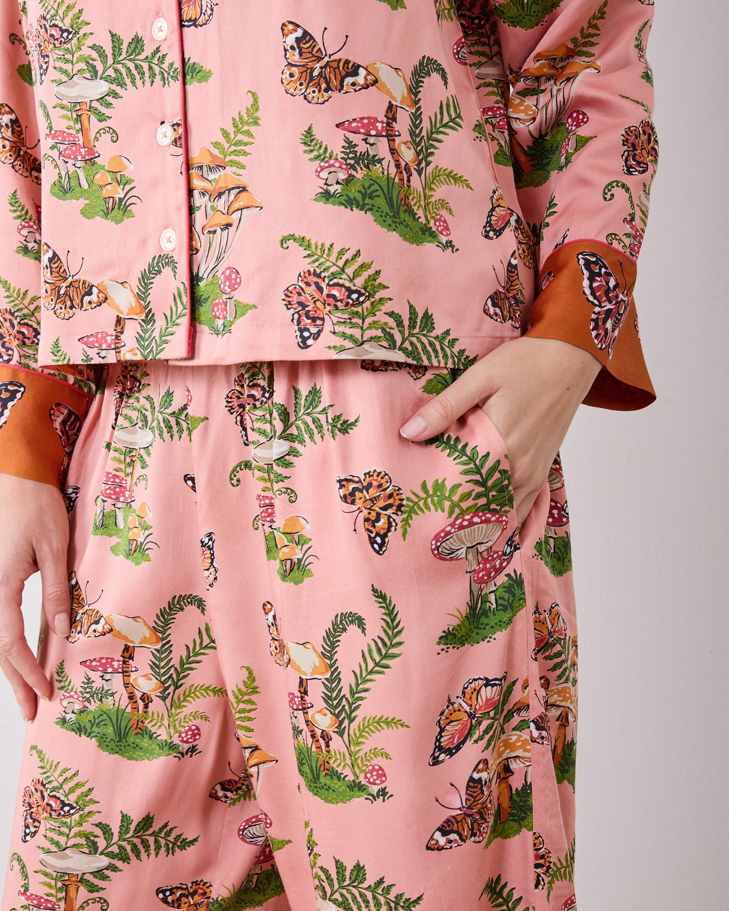 Close-up of the Butterfly Forager pajama set showing the button-front top, patterned wide-leg pants, and side pocket.