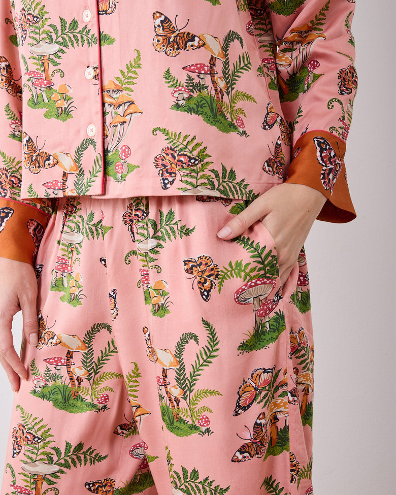 Close-up of the Butterfly Forager pajama set showing the button-front top, patterned wide-leg pants, and side pocket.