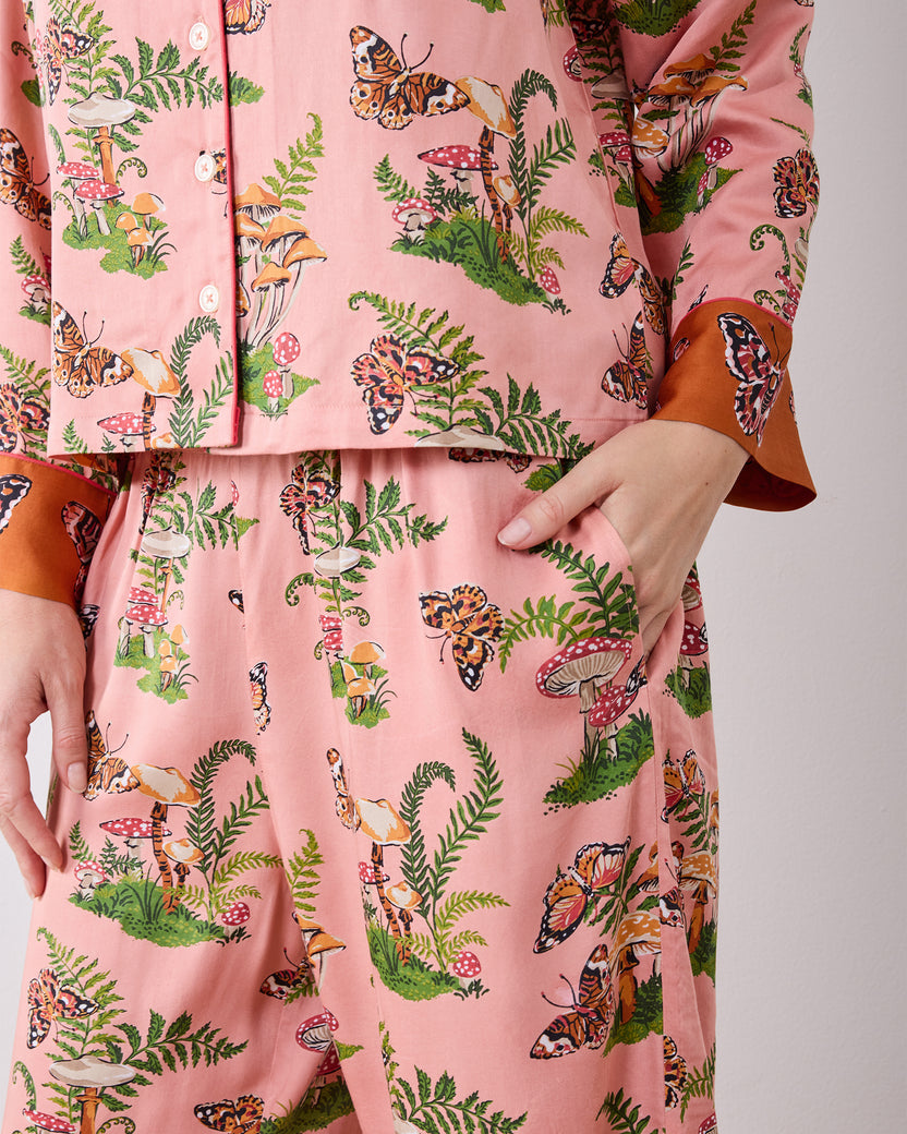 Close-up of the Butterfly Forager pajama set showing the button-front top, patterned wide-leg pants, and side pocket.