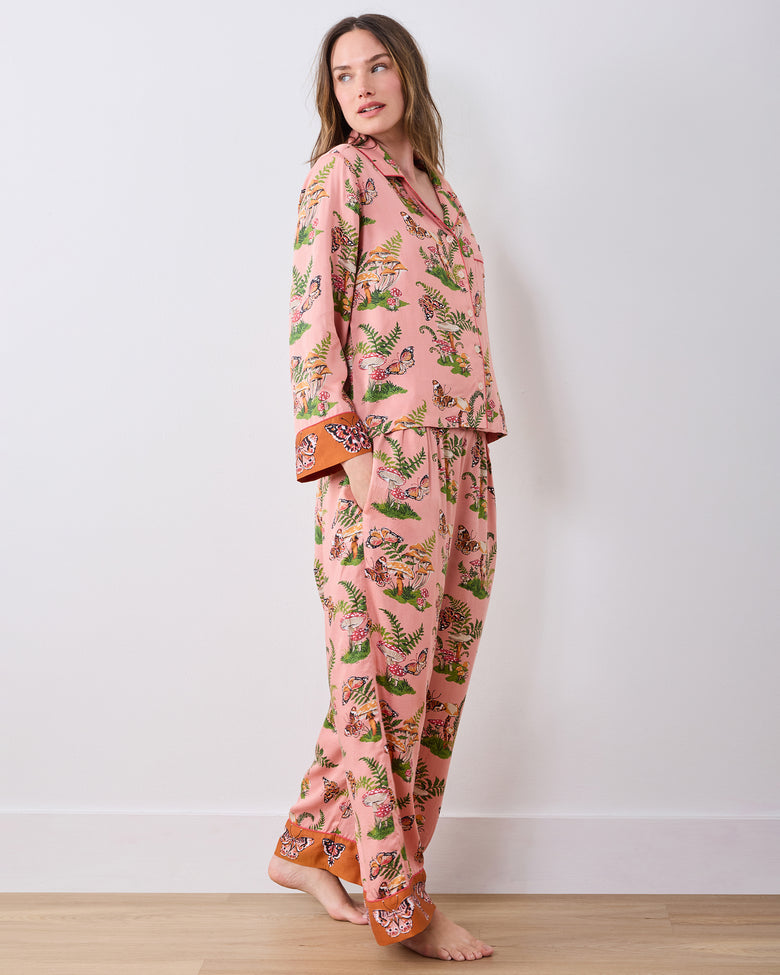 Side view of a model wearing the pink Butterfly Forager pajama set with a button-front top and wide-leg pants.