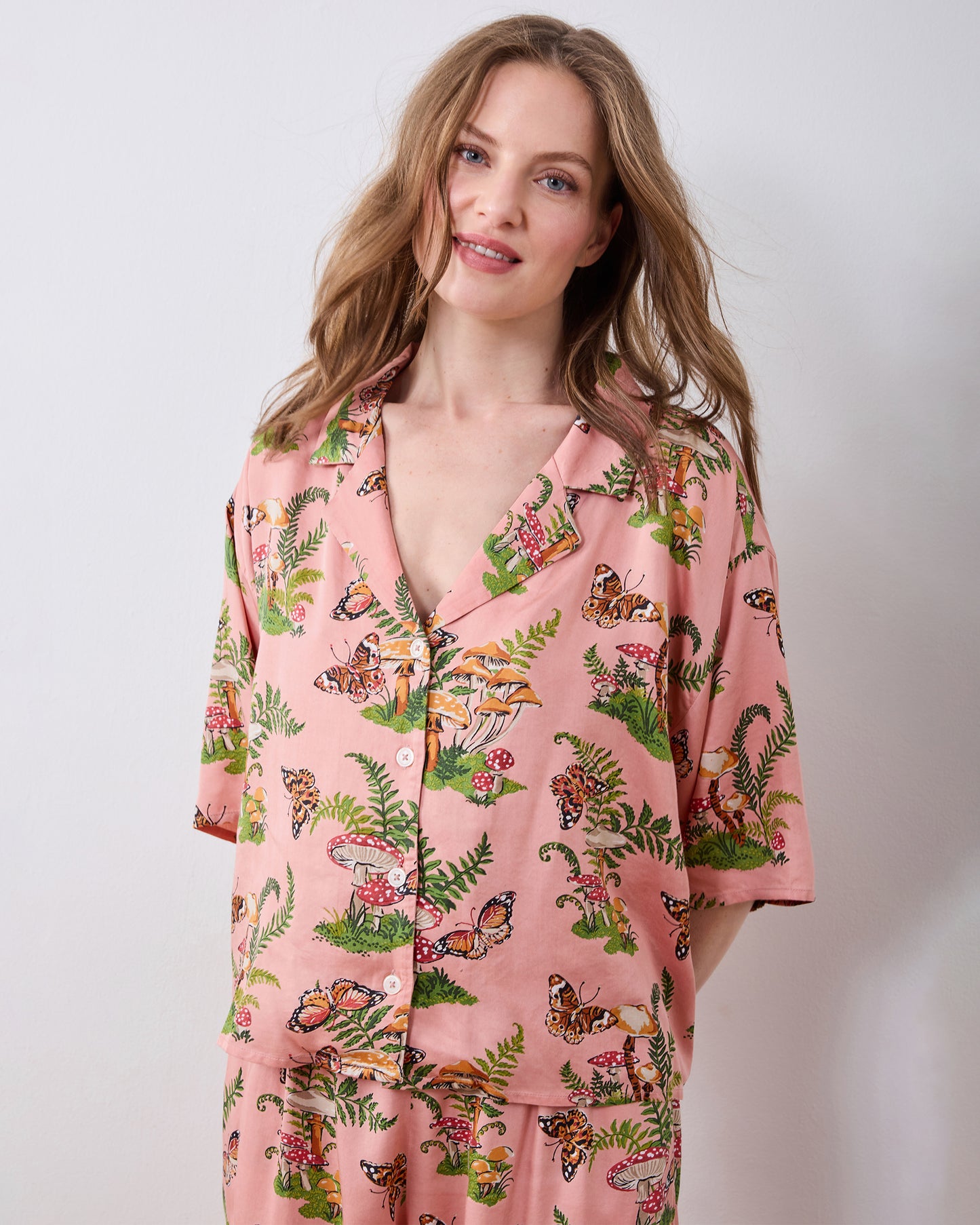 Front view of the pink Butterfly Forager tall satin Wildest Dreams pajama set with a button-front short-sleeved top and wide-leg pants.