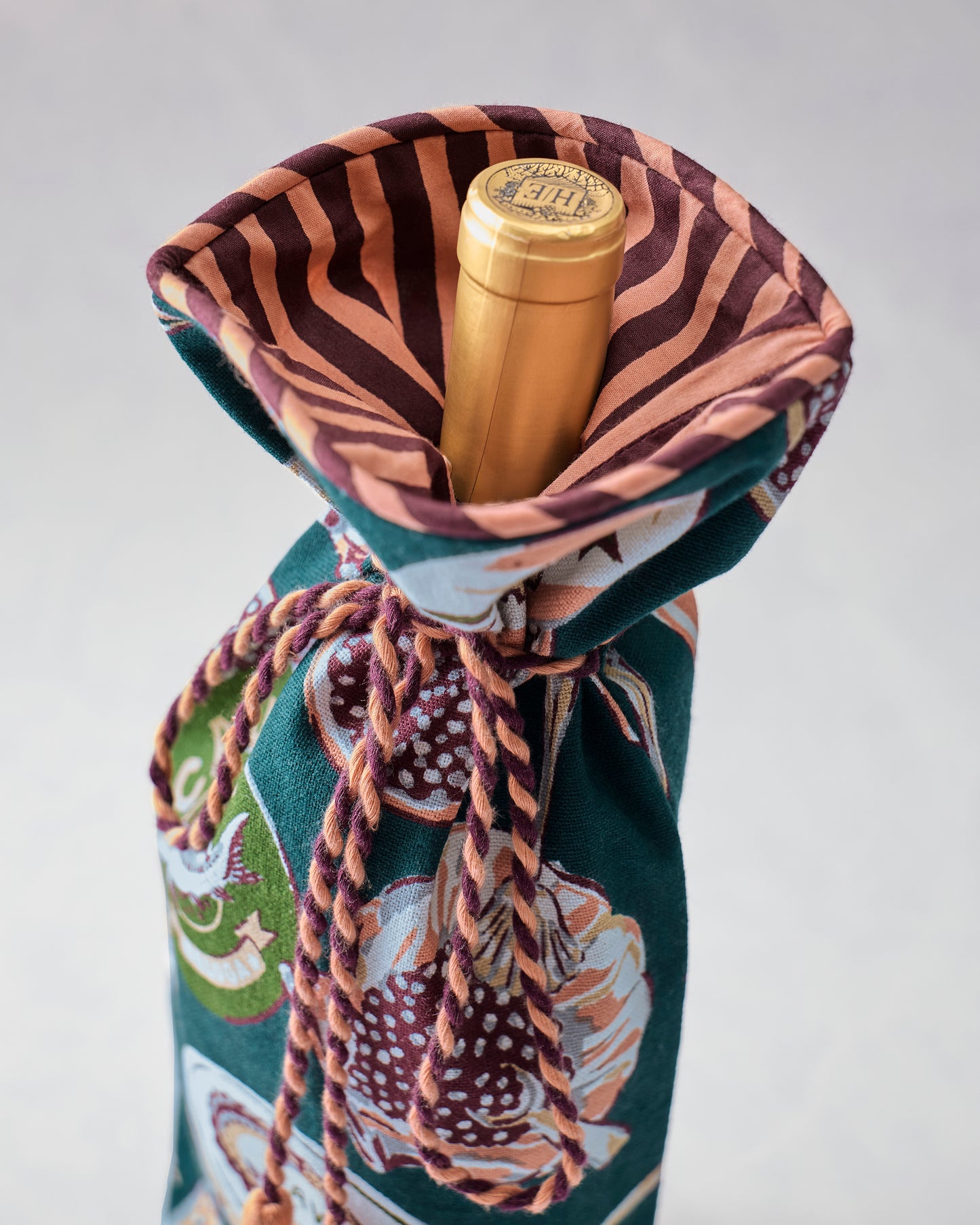 Open Champagne & Caviar wine bag displaying its striped lining and the top of a bottle inside.