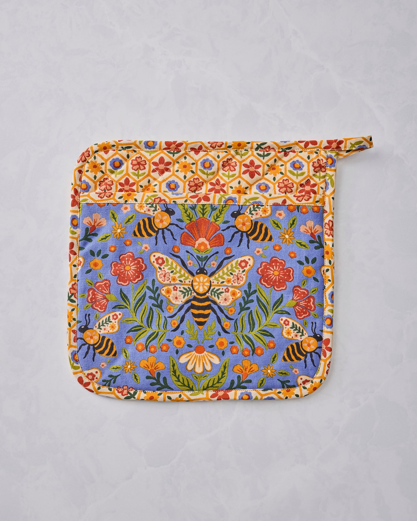 Bee Tapestry pot holder shown flat with a blue floral-and-bee center, cream floral-patterned border, and hanging loop.