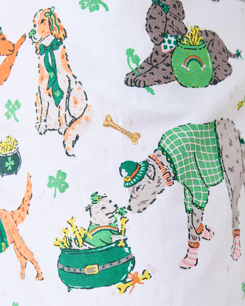Close-up of the pajama print with dressed dogs, clovers, pots, rainbows, and an embroidered gold bone