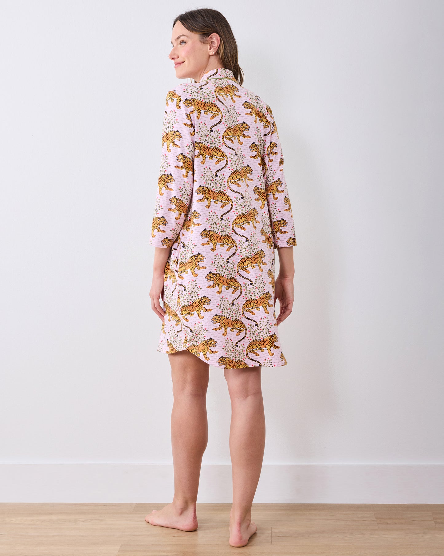 Back view of a person wearing a pink leopard-and-floral print button-front sleep shirt with three-quarter sleeves.