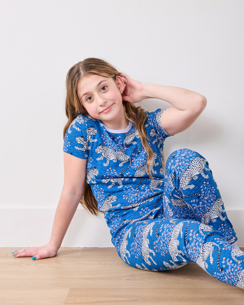 Model seated on the floor wearing the indigo Bagheera short-sleeve top and pajama pants