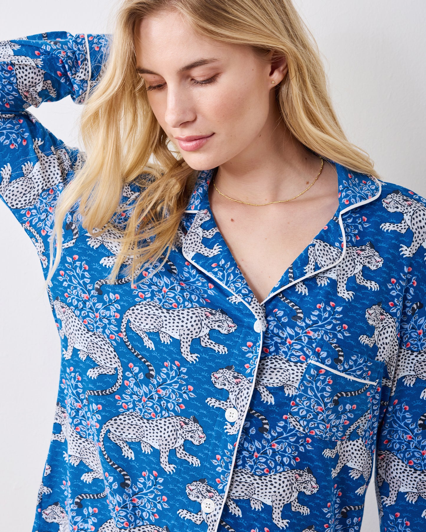 Close view of the indigo leopard-print pajama top with white piping, buttons, and chest pocket