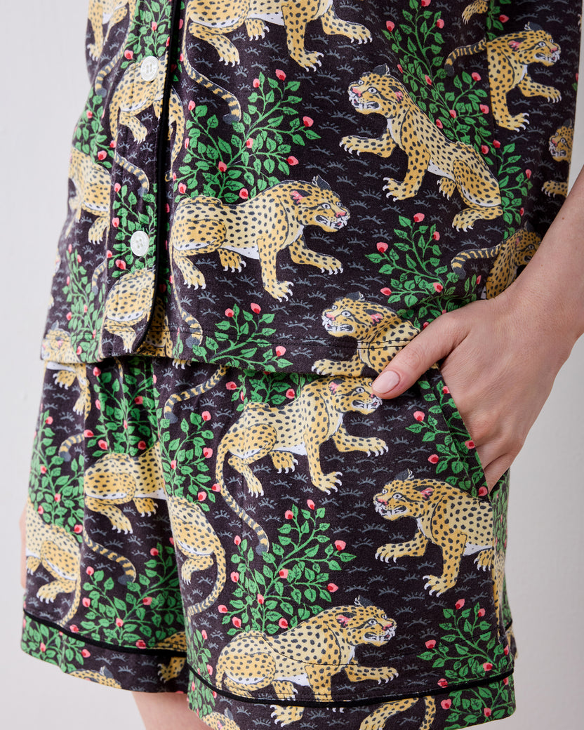 Close-up of the Bagheera short pajama set showing leopard-print shorts, a shirt hem, white buttons, and a side pocket.