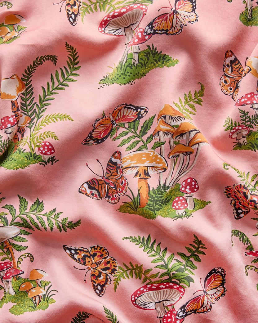 Close-up of the rosewood Butterfly Forager print featuring butterflies, mushrooms, and fern fronds.
