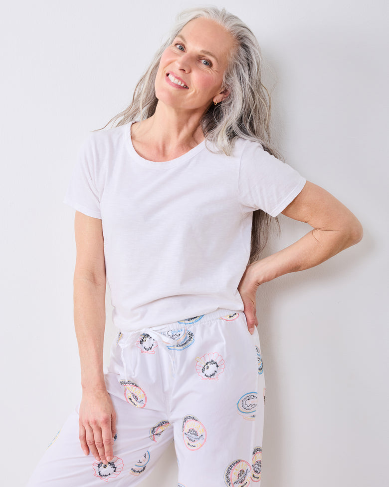 Front view of a person wearing the pearl embroidered pajama pants with a plain white T-shirt.