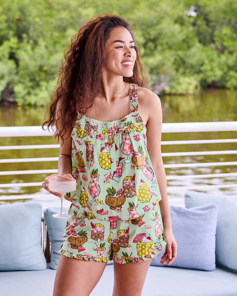 Mojito sleeveless top and ruffled shorts set shown by the water, with the model holding a drink