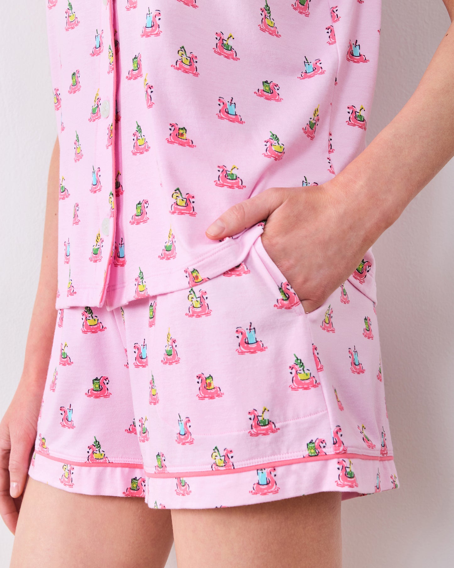 Close-up of the flamingo-print pajama shorts with a hand inside the side pocket