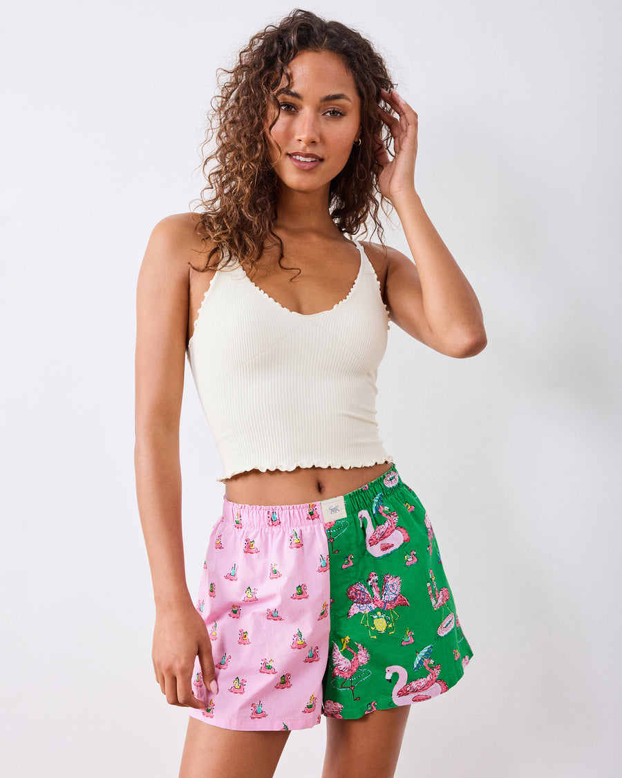 Front view of the pink-and-green flamingo-print boxer shorts worn with a white cropped top