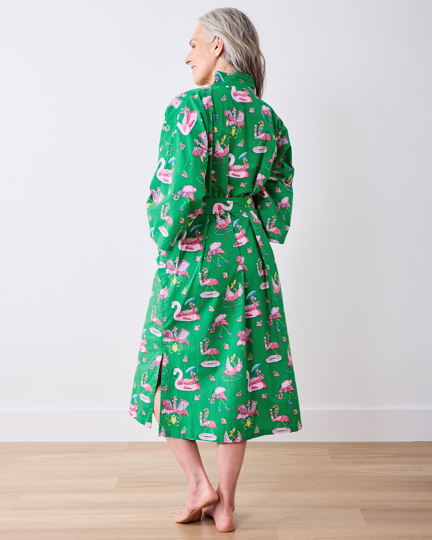 Full-length back view of the green flamingo-print long robe tied at the waist