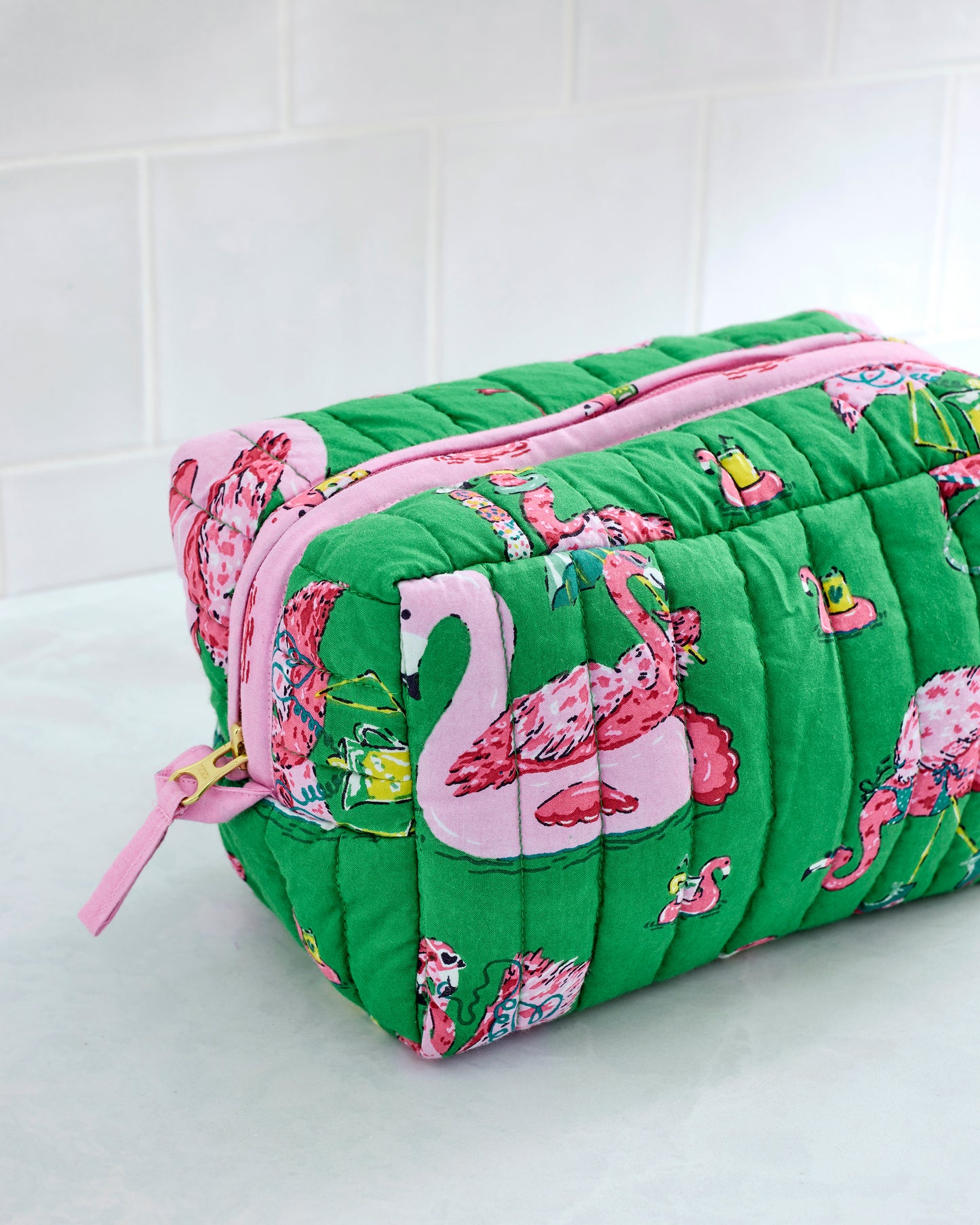 Close-up of the large green quilted pouch with pink zipper and flamingo print