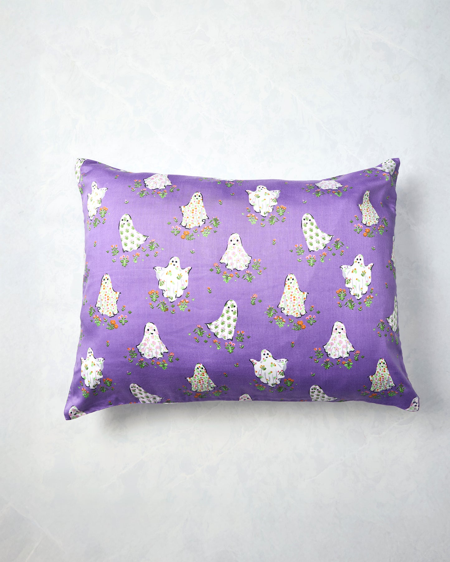 Eerie Amethyst pillowcase displayed flat with a purple background and a repeating print of white ghosts surrounded by small flowers.