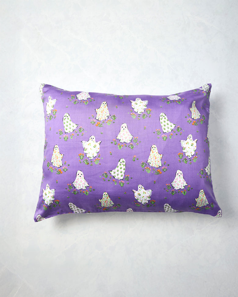Eerie Amethyst pillowcase displayed flat with a purple background and a repeating print of white ghosts surrounded by small flowers.